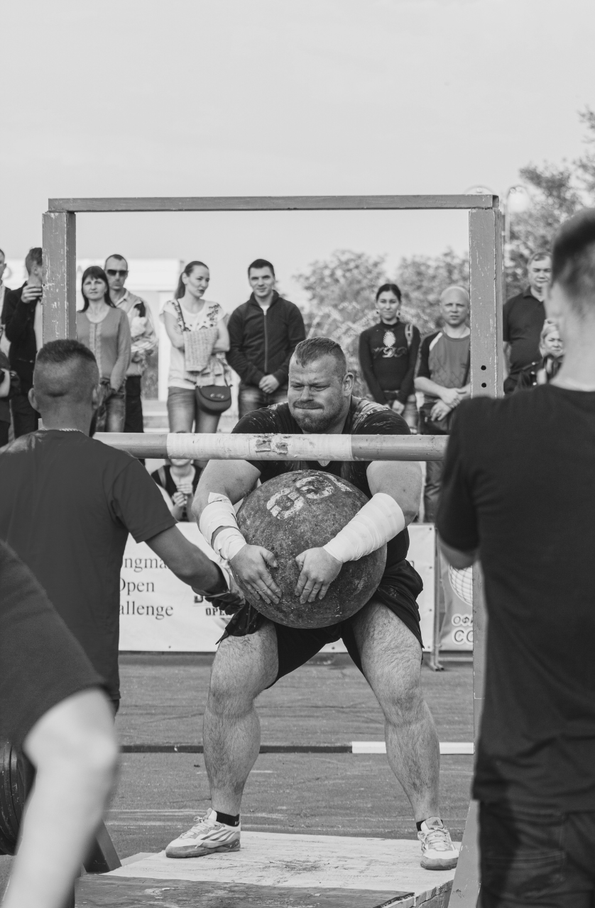 Zawodnik podczas zawodów siłowych trzymający kulę, przygotowujący się psychicznie do startu