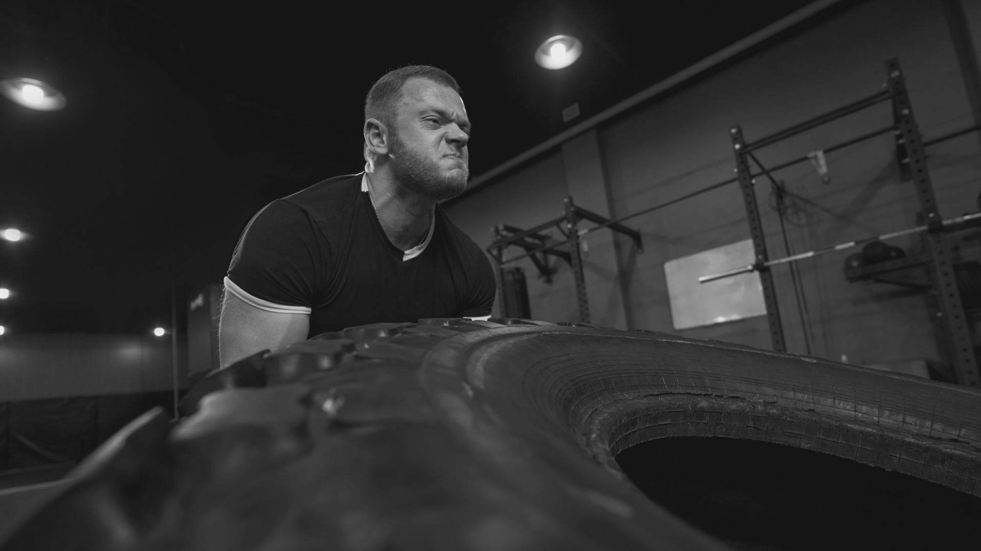 Zawodnik podnoszący oponę podczas treningu siłowego – trening mentalny i fizyczny